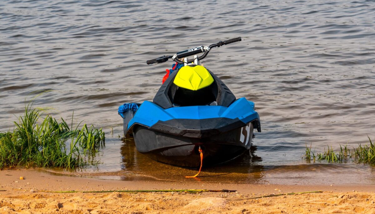 Blue PWC sitting on the edge of a lakeside beach