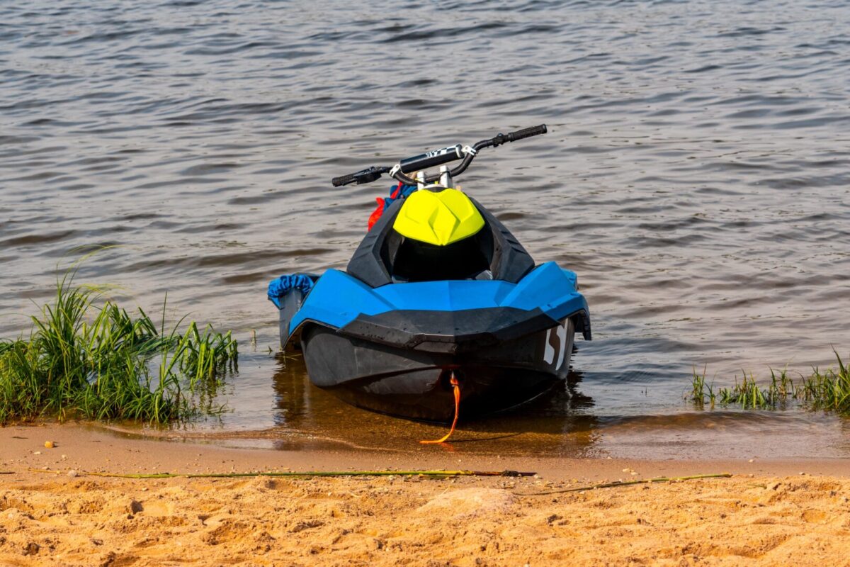 Blue PWC sitting on the edge of a lakeside beach
