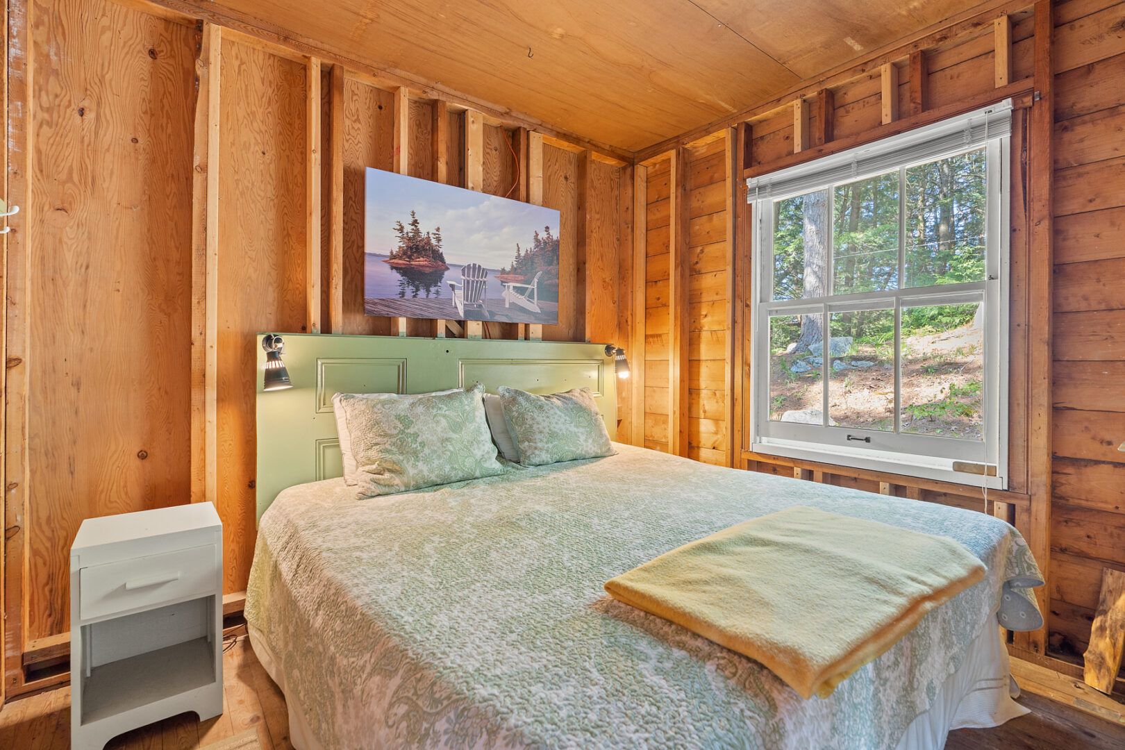A bright bedroom with a big bed and a large window.
