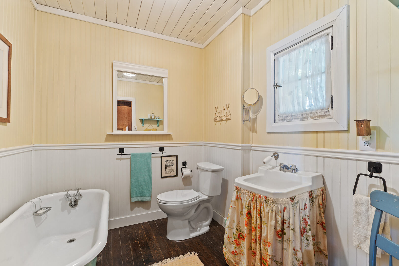 A large, bright bathroom with a toilet, a sink, and a bathtub.