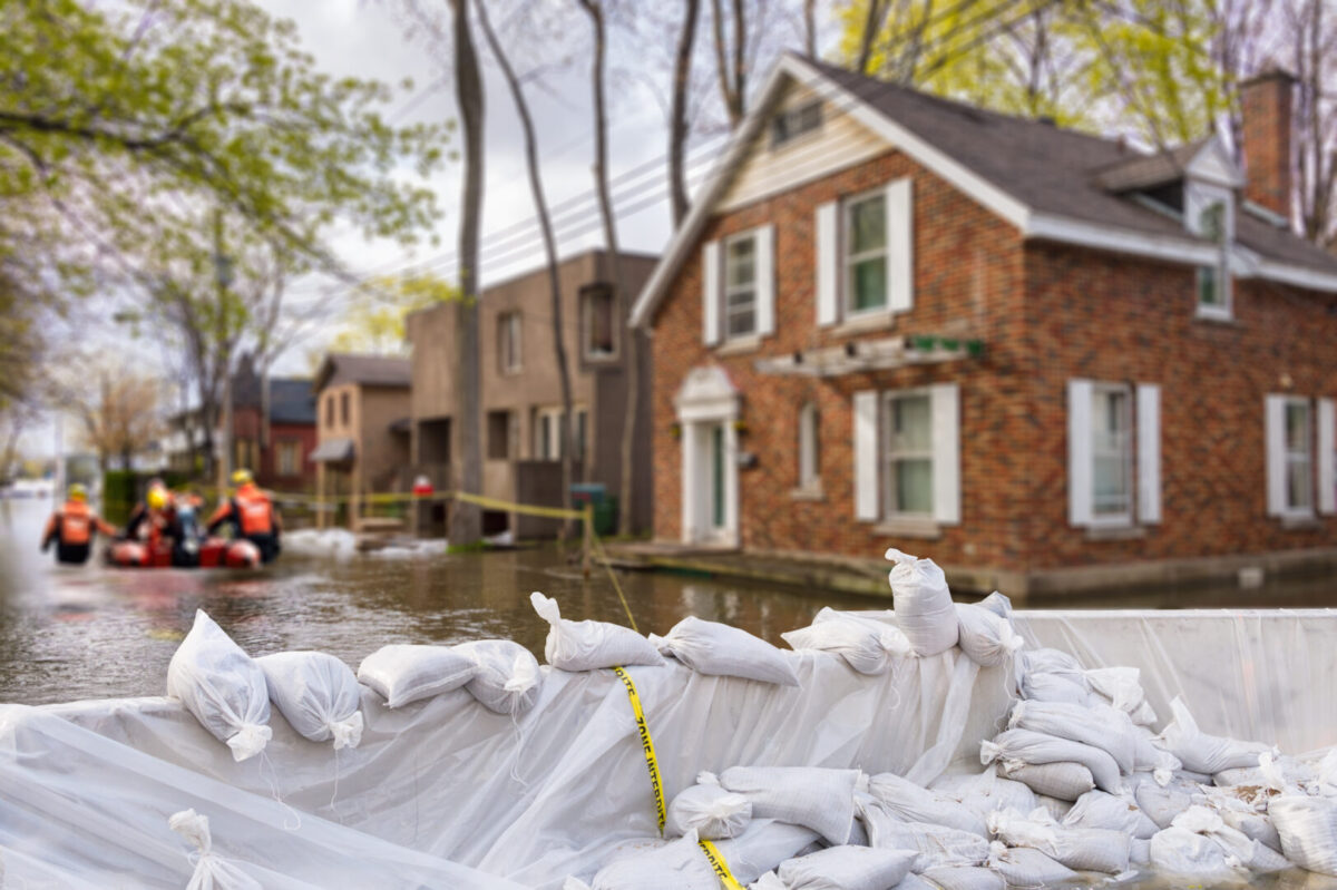 flooded house with sandbags in front of it