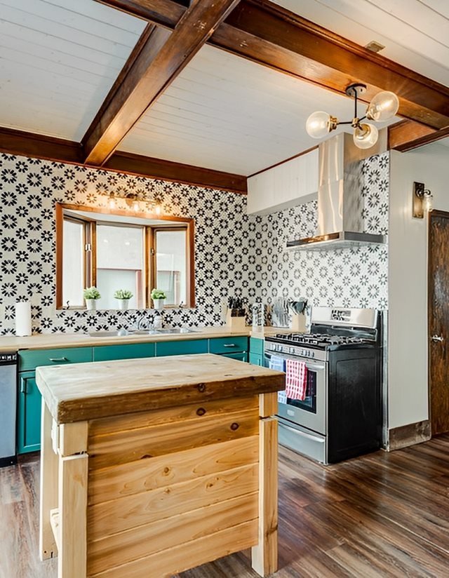 kitchen with green cabinets and patterned wall paper