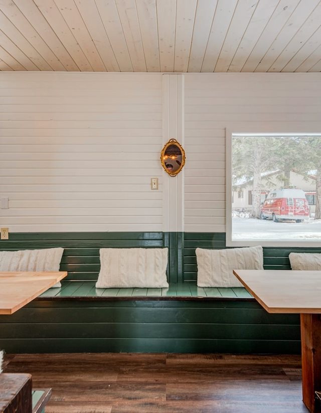 seating area with green wooden benches and pillows