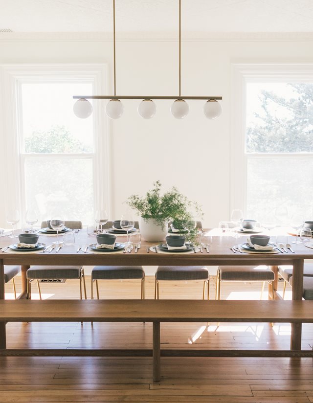 wooden dining table with table settings in white room