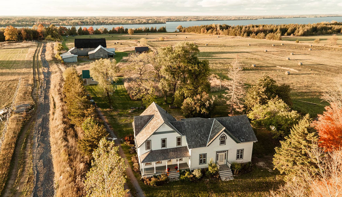 aerial view of farmhouse and surrounding lands with river in the background