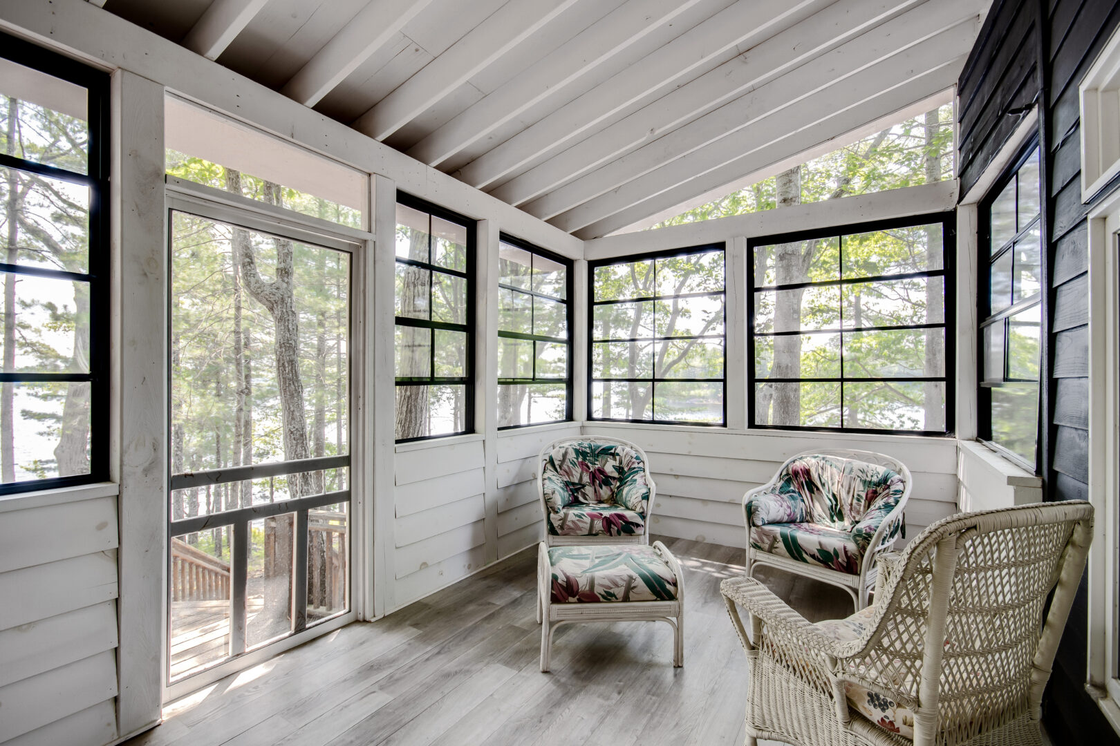 A sunny Muskoka room with a white interior and lots of windows.