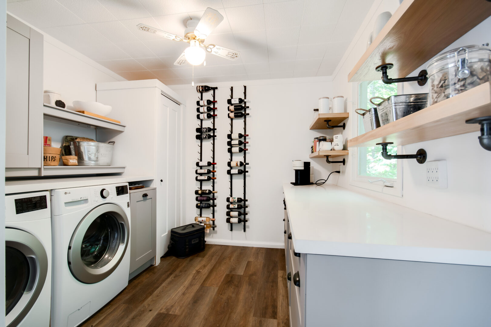 A large, bright area with a washing machine, a dryer, and hardwood floors.
