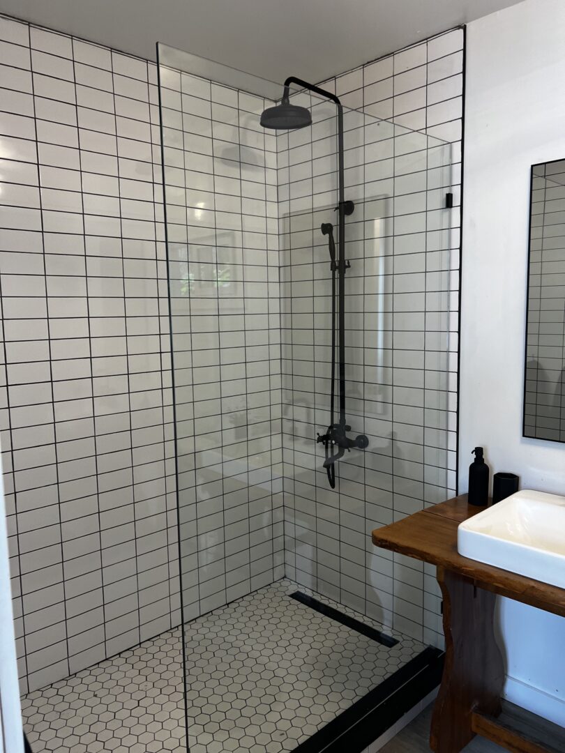 A bathroom with a large walk-in shower and a sink.