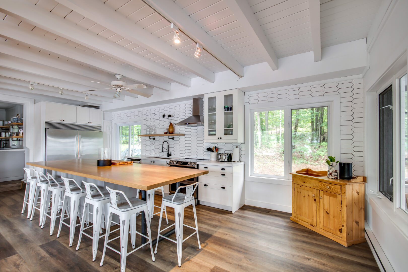 A bright kitchen and dining area with a large island and chairs.