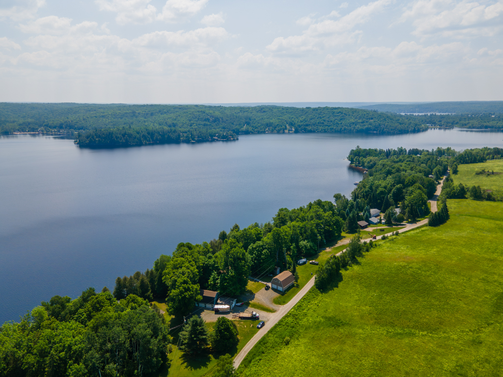 Green trees line the shore of a wide blue lake.