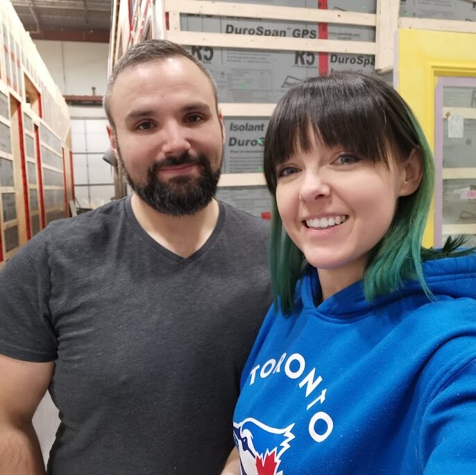 Photo of the couple in the warehouse where their tiny home was being built