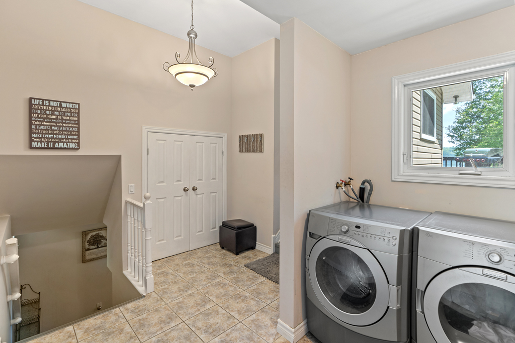 A modern washing machine and dryer sit in a small foyer.