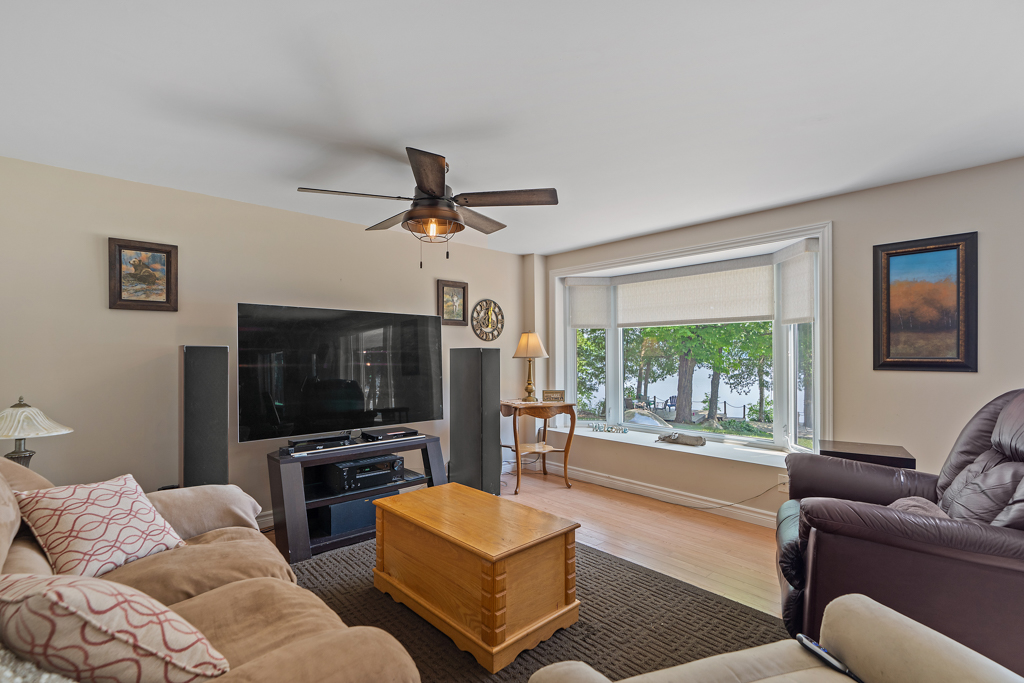A small living space with a couch, a big window, and a television.