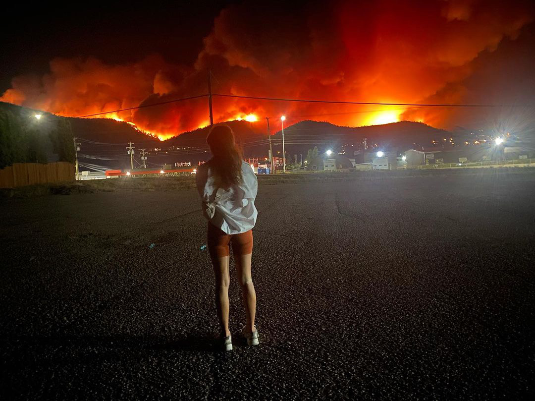 girl standing in front of wildfire