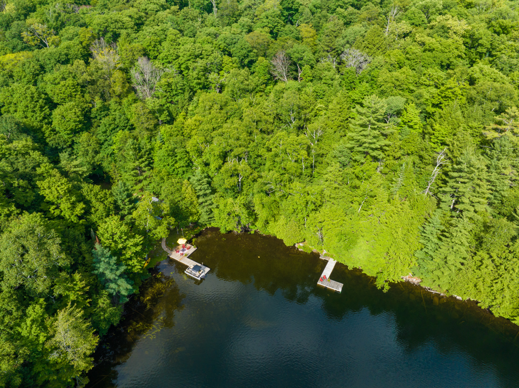 Overhead view of a small bay on a lake, with two docks extending into the water front different points on the shore.