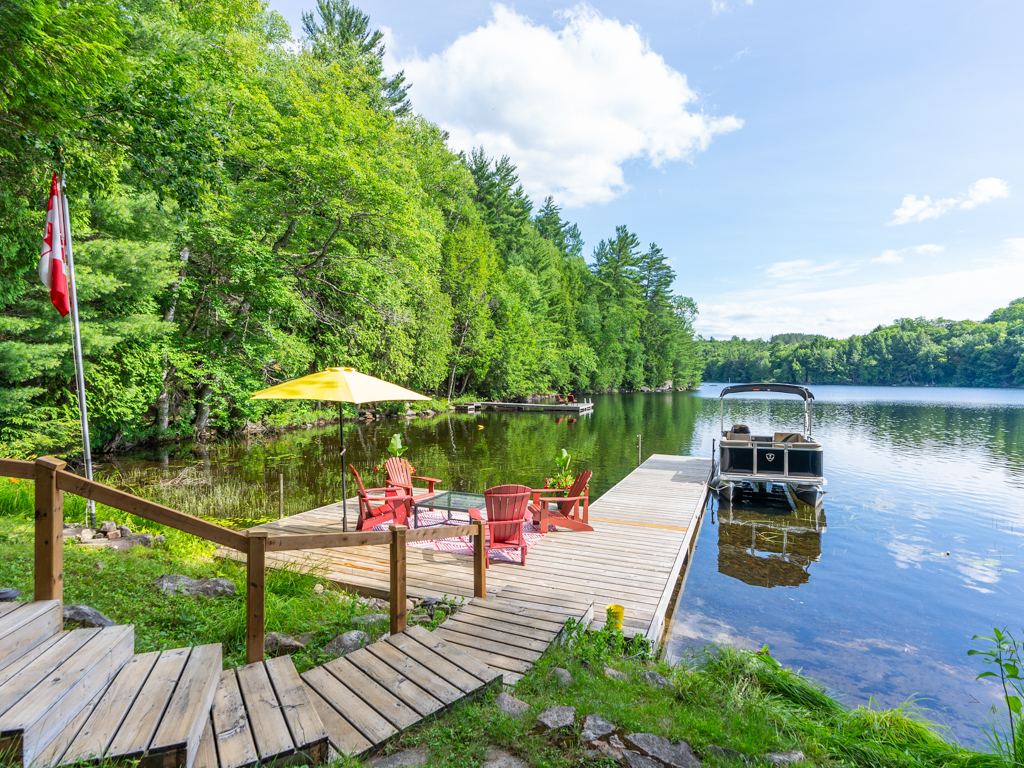 Stairs leading down to a long dock that stretches into a calm lake.