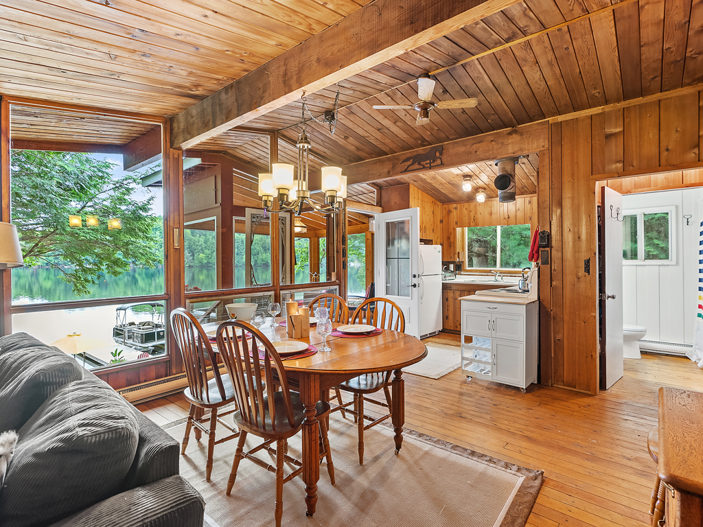 A small cottage dining area with a table and chairs, just off a kitchen.