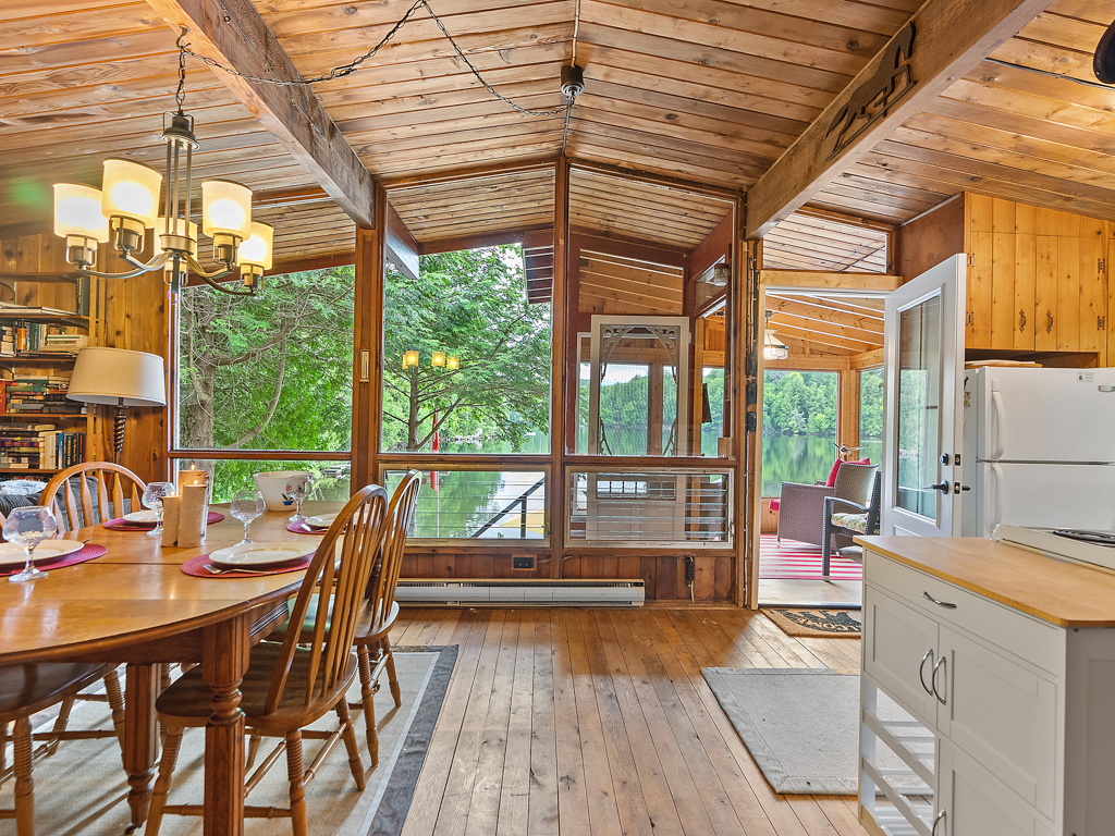 Floor-to-ceiling windows in a cottage living space look out to lake views and let in lots of natural light.