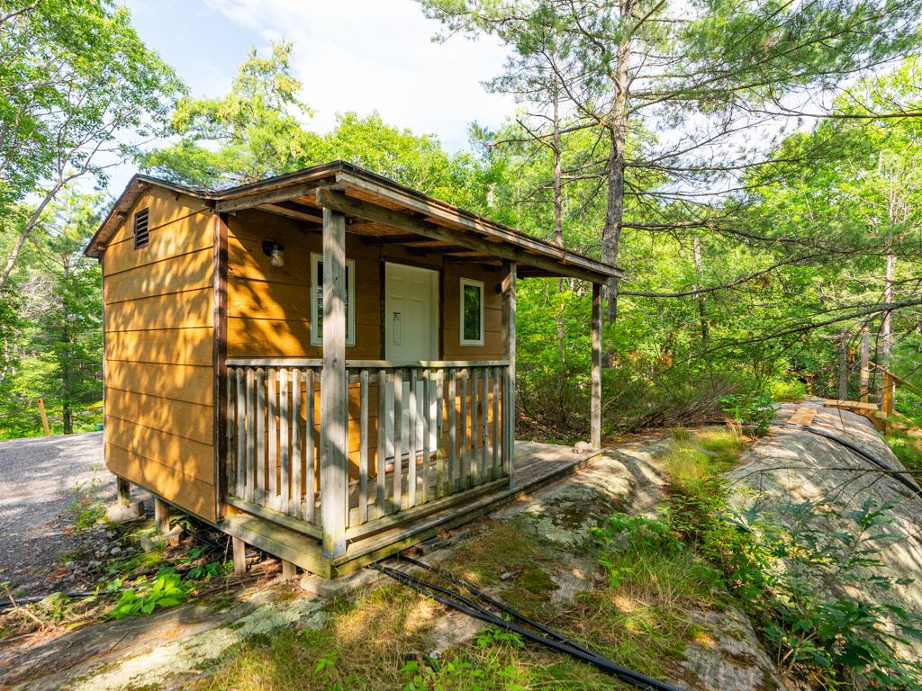 A small extra building with a front door and a porch.