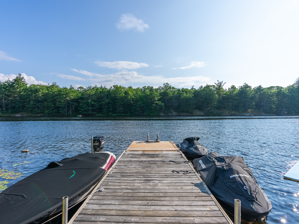 A long stretch of dock looks out to a blue lake.