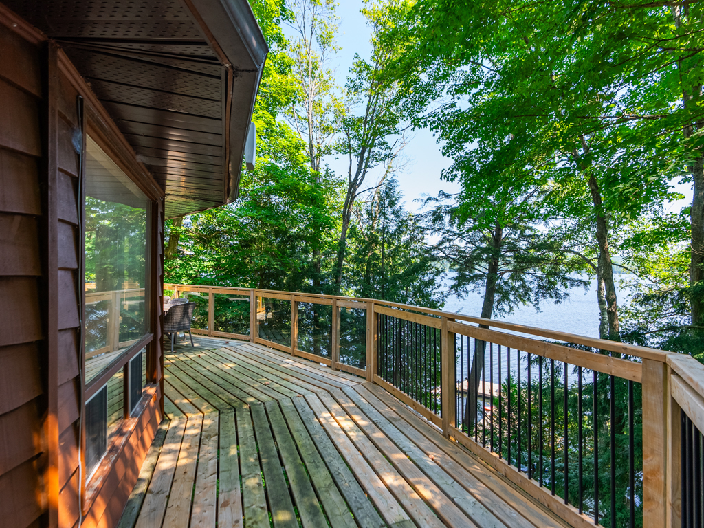 A wraparound deck extends around the curving side of a round cottage.