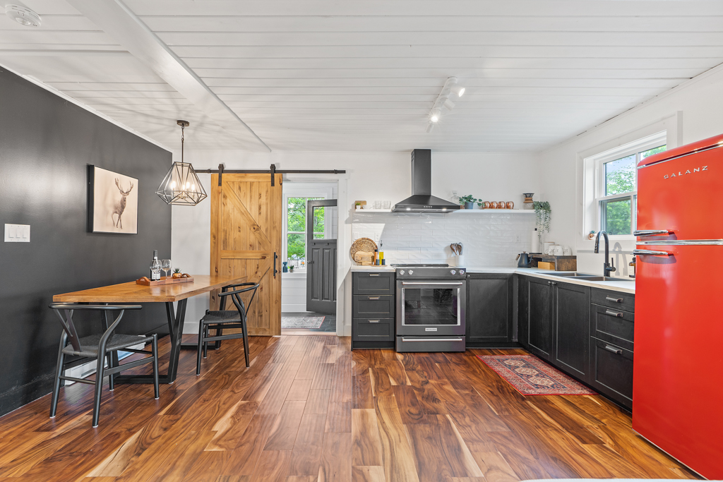 An open-concept area inside the entrance of a home, with a kitchen area to one side and a dining area to the other.