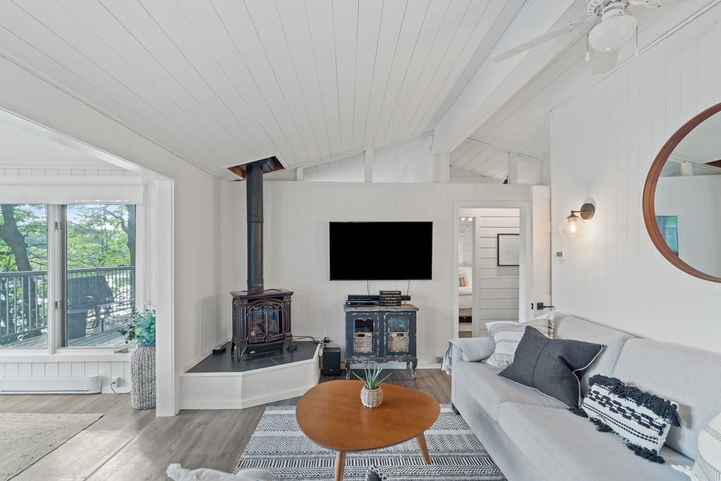 A small living area with a couch, a wood stove, and a television.