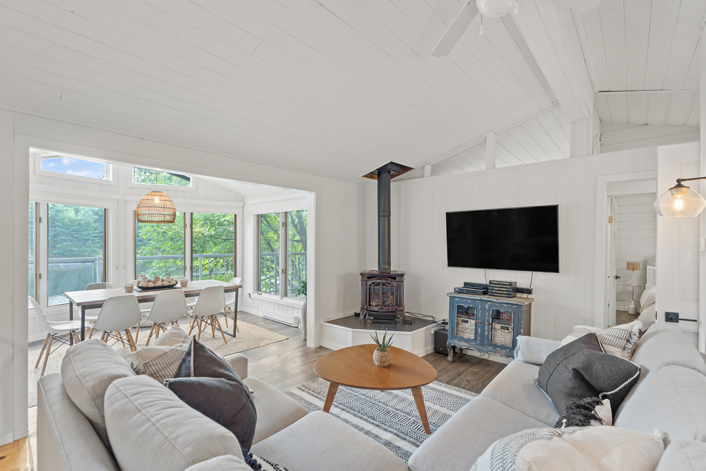 A small living area with a couch, a wood stove, and a television.