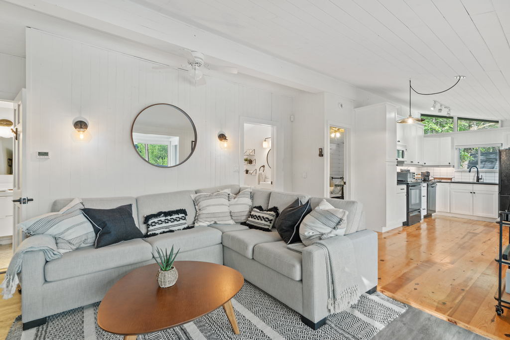 A living area with a couch and a coffee table, that flows into a kitchen space.