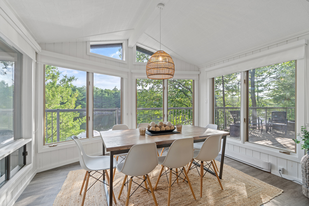 A bright dining area with a table and chairs in front of lots of windows.