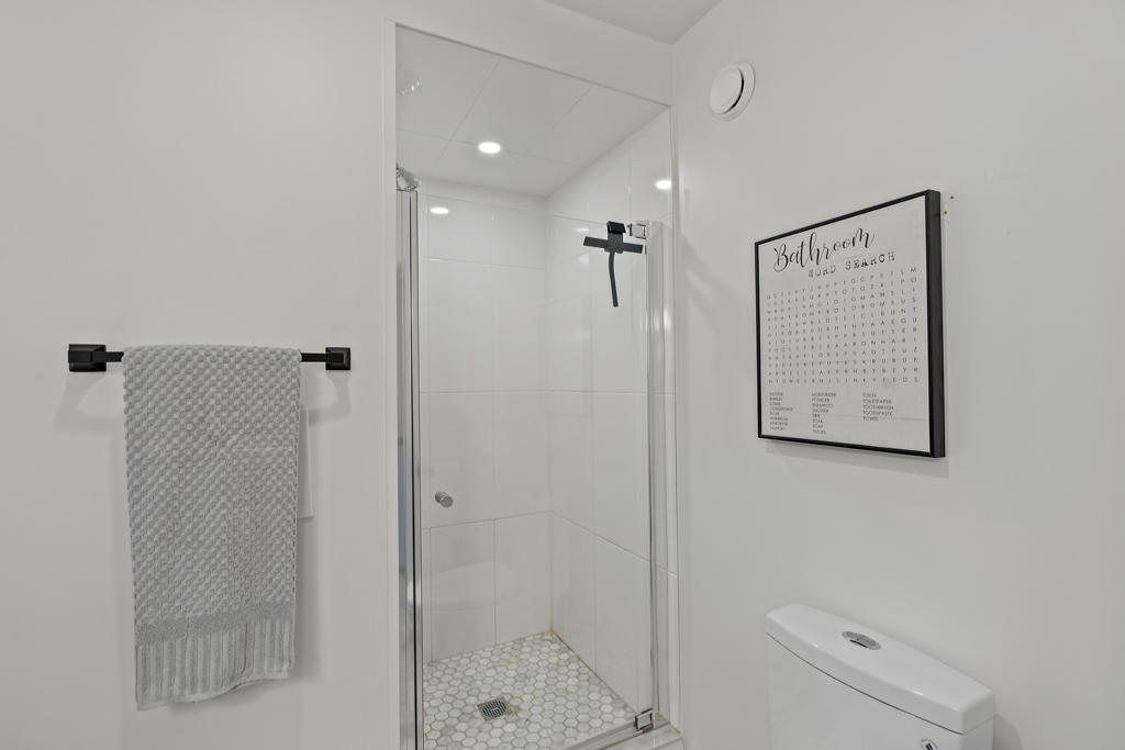 A big bathroom with a walk-in shower and a toilet.