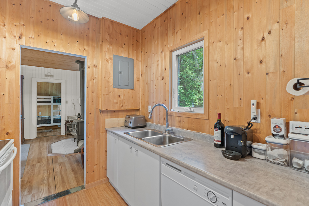 A narrow kitchen with wood-panelled walls.