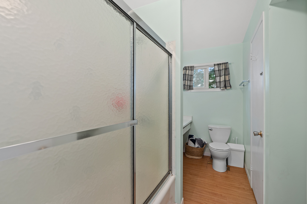 A bathroom with a shower-tub combo and a toilet.