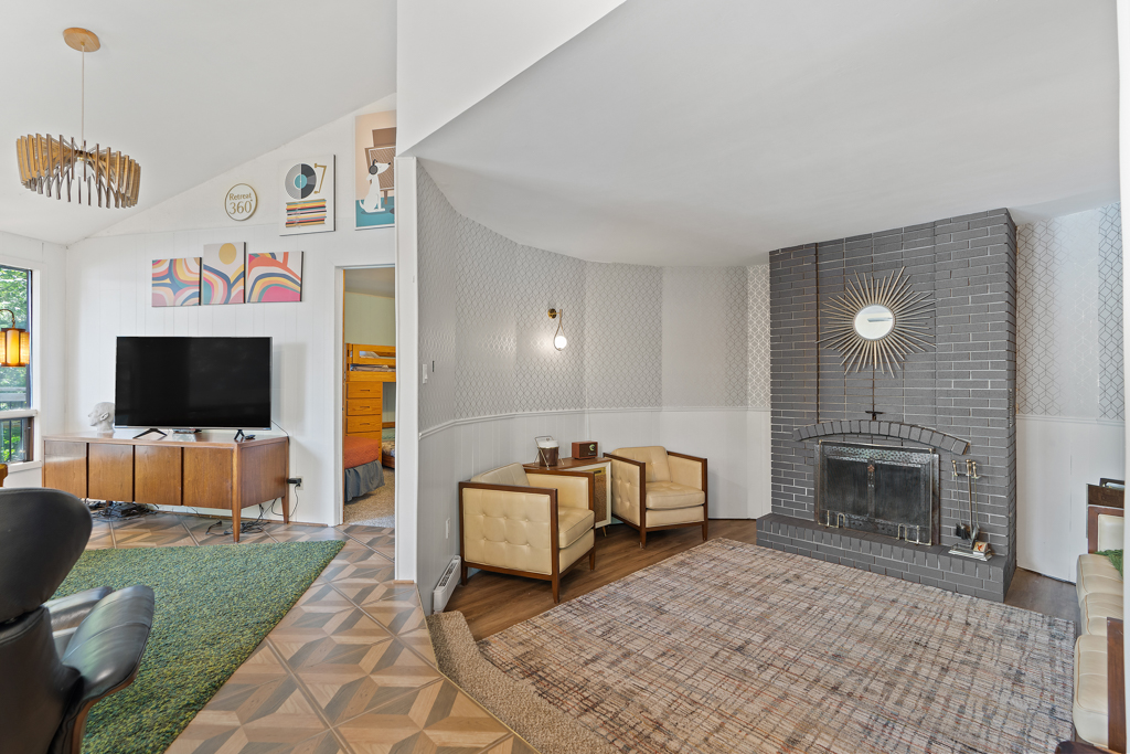 Two steps lead down from a bright living area into a sunken den.