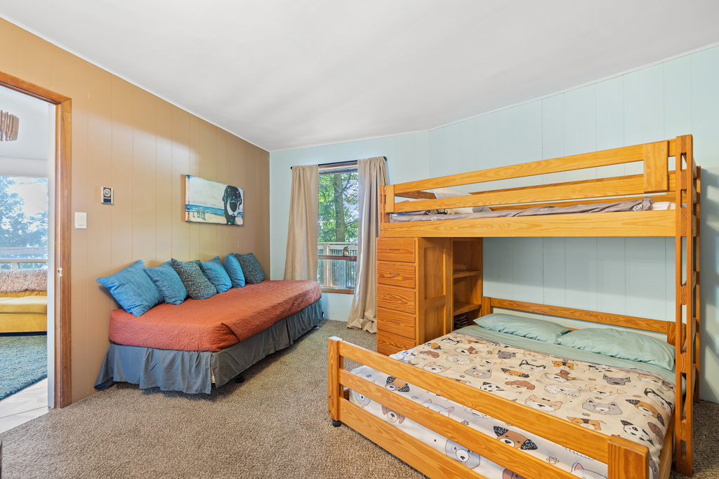 A bedroom with a couch and bunkbeds.