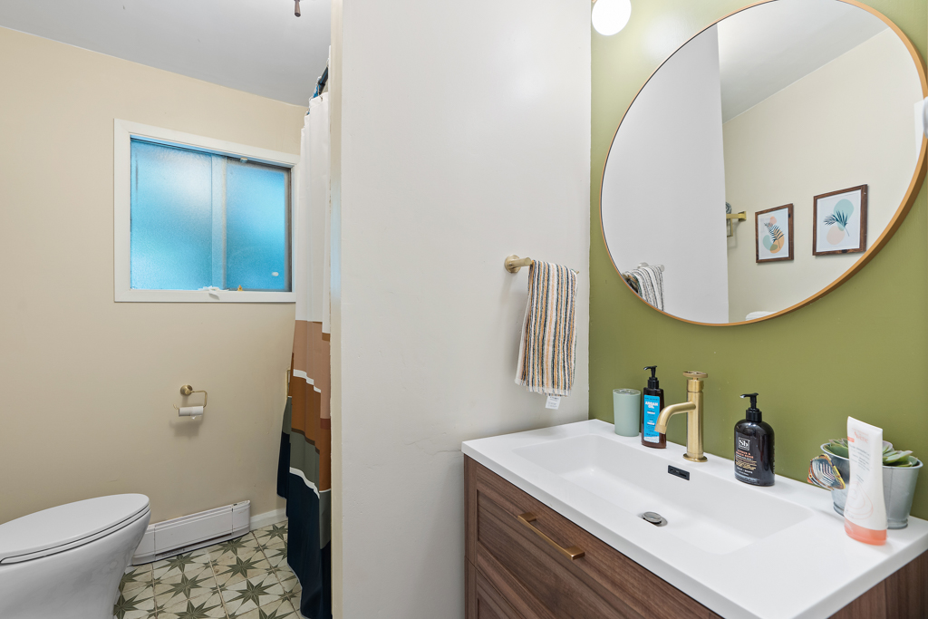 A bathroom with a sink, a toilet, and retro-style tile.
