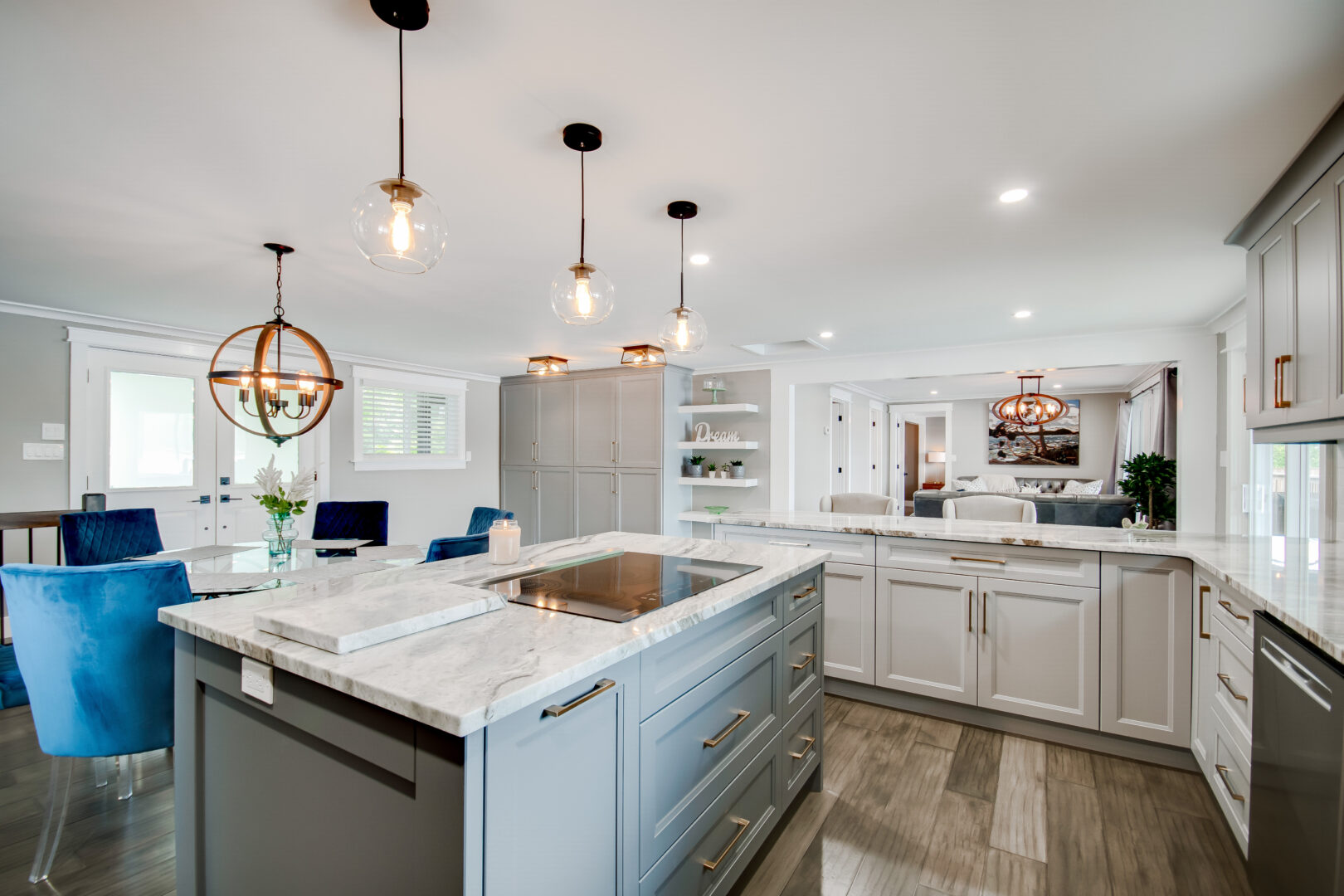 An updated, modern kitchen with new appliances, white cupboards and countertops, and a pale blue island.