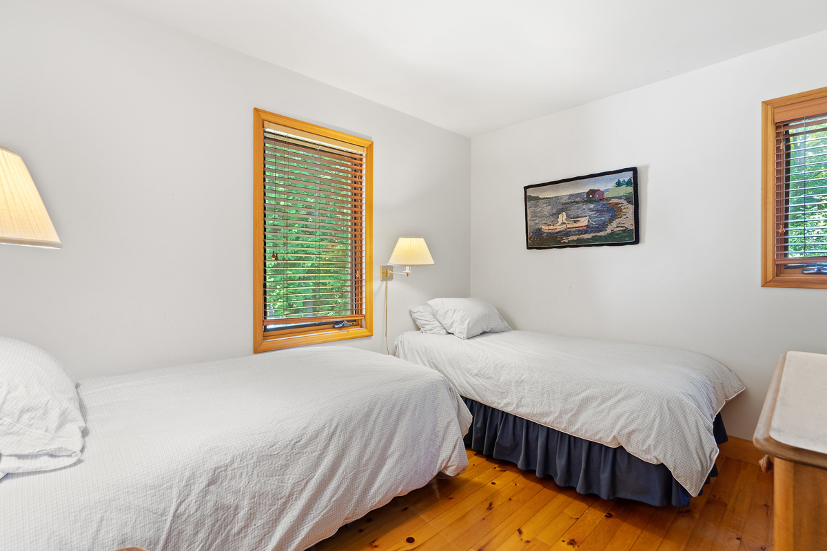 A bright bedroom with two small beds.