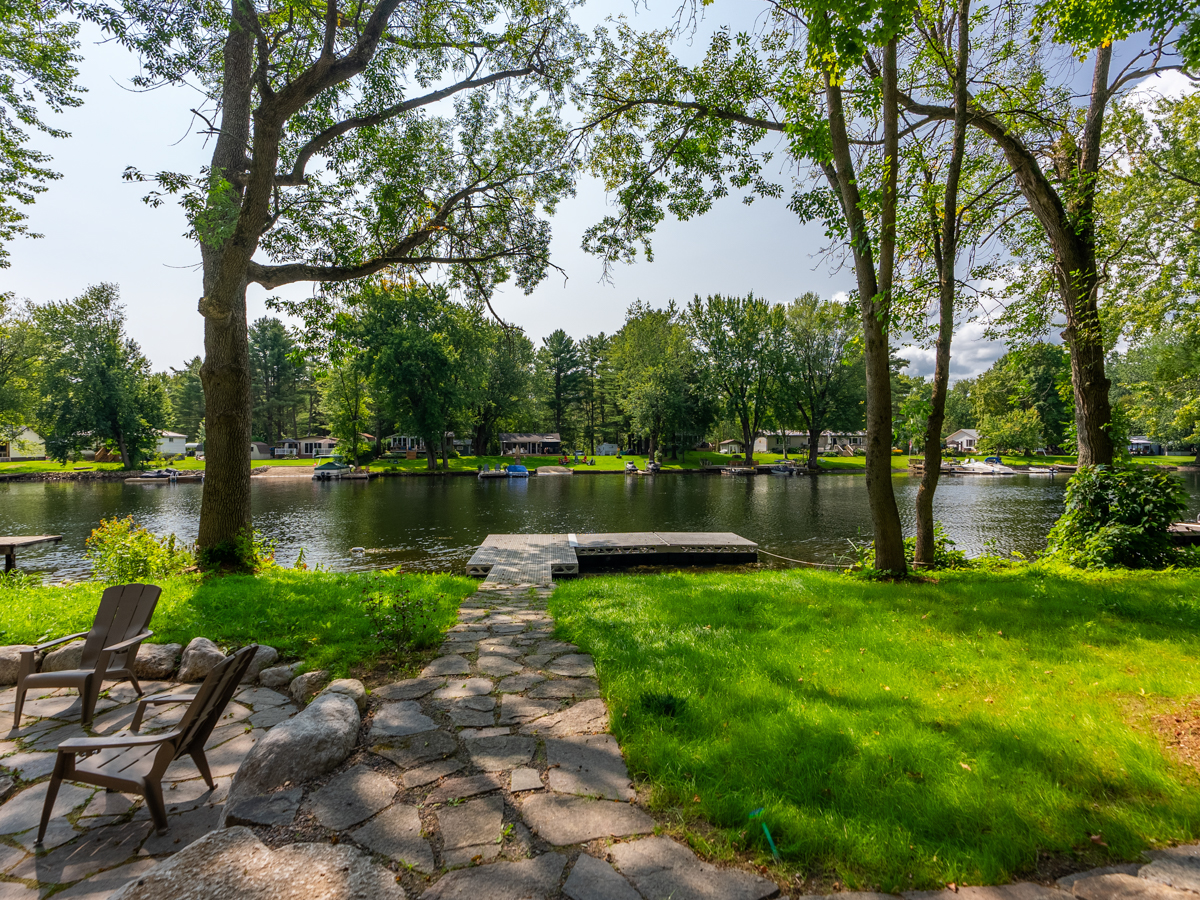 A patio walkway leading down to a dock on a river.