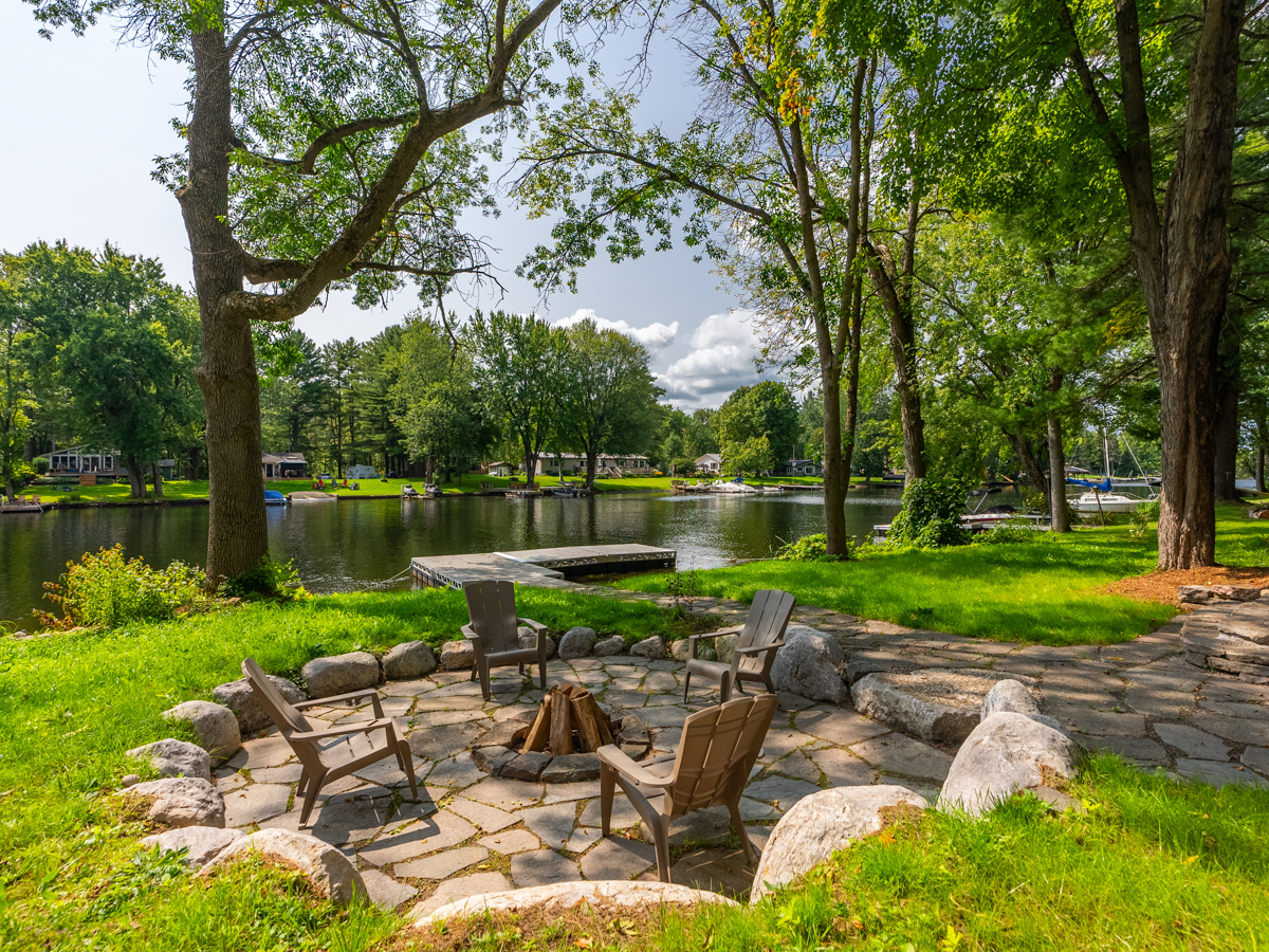 A large fire pit area with two Muskoka chairs.