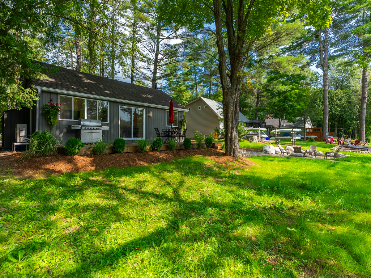 A wide, grassy yard in front of a cottage.