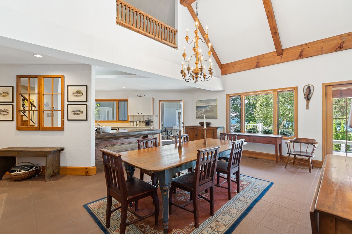 A bright, open-concept main floor space of a luxury cottage, with a dining area leading into a kitchen.