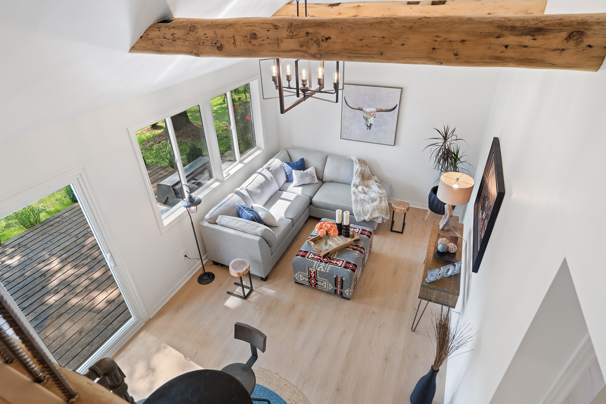 View down from a loft space into a living and dining area.