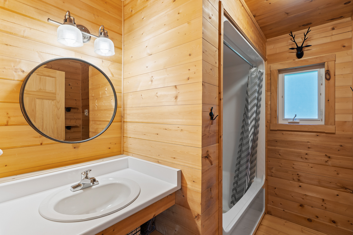 A bathroom with a sink and a bathtub-shower combo.