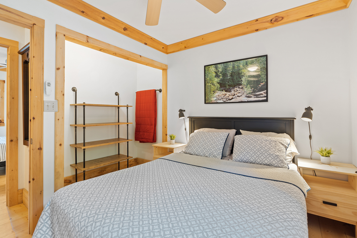 A bedroom with a big bed and storage shelves.