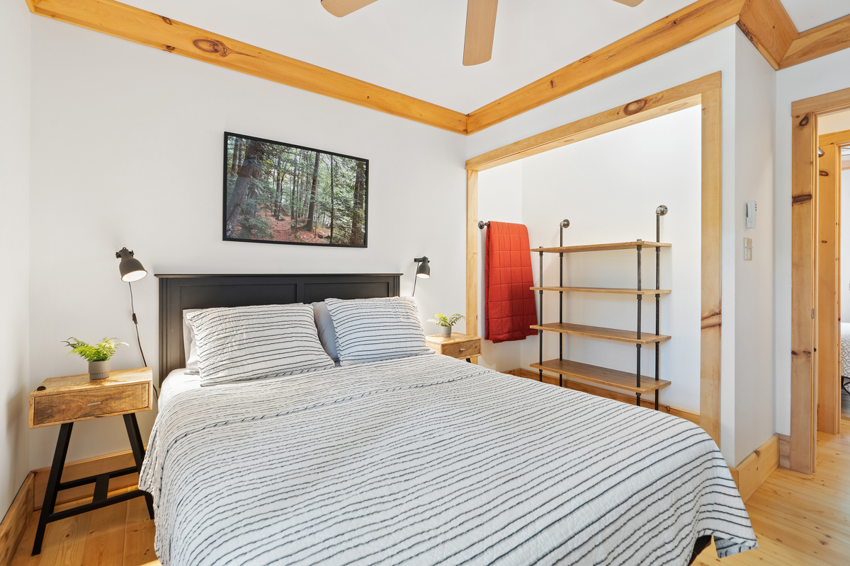 A bedroom with a big bed and storage shelves.