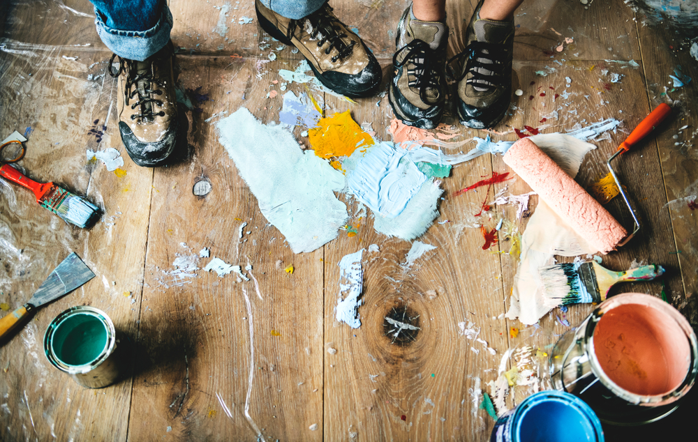 People renovating the house with paint all over the floor