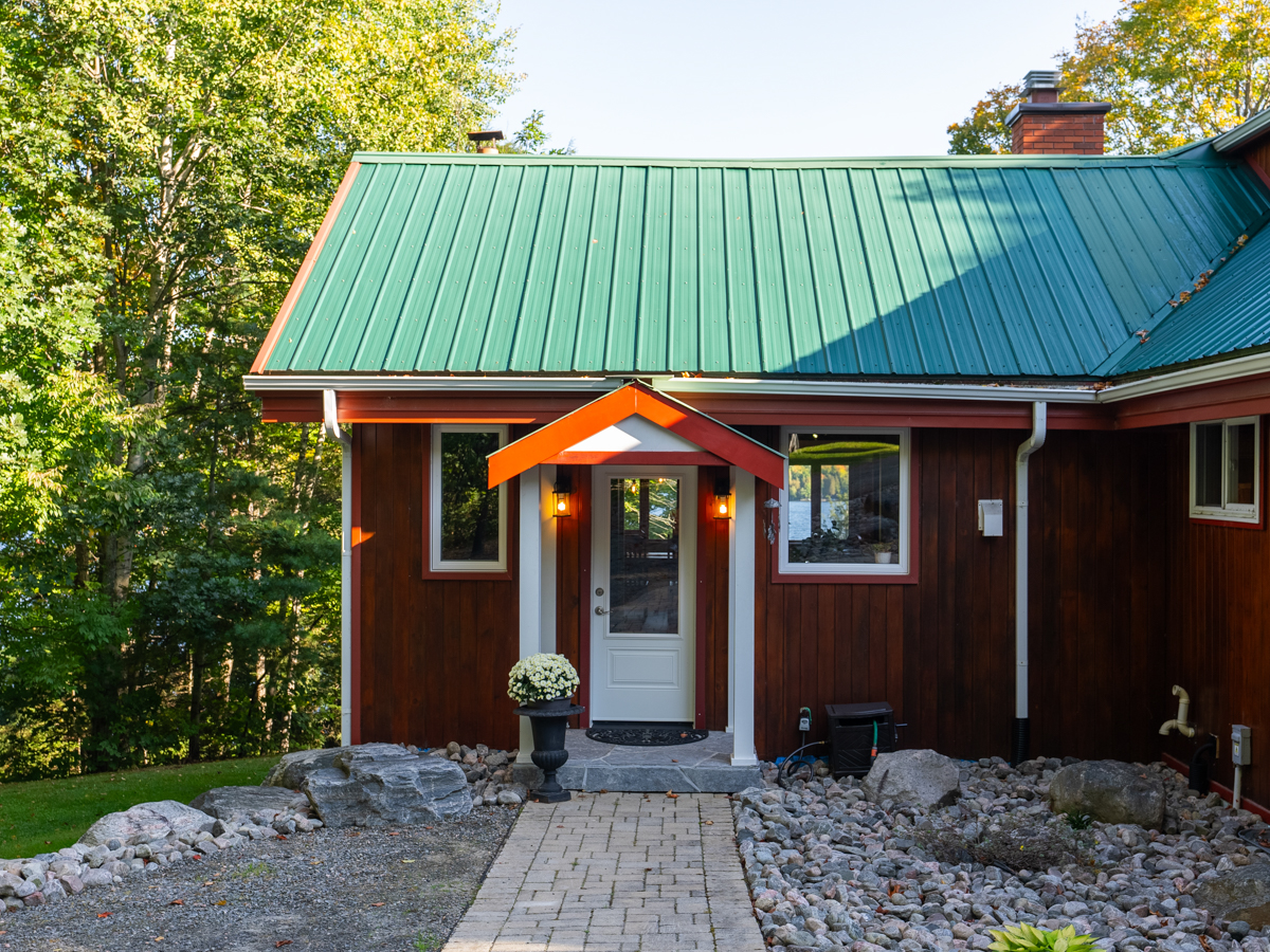 Front entrance of a cottage, with a white door.