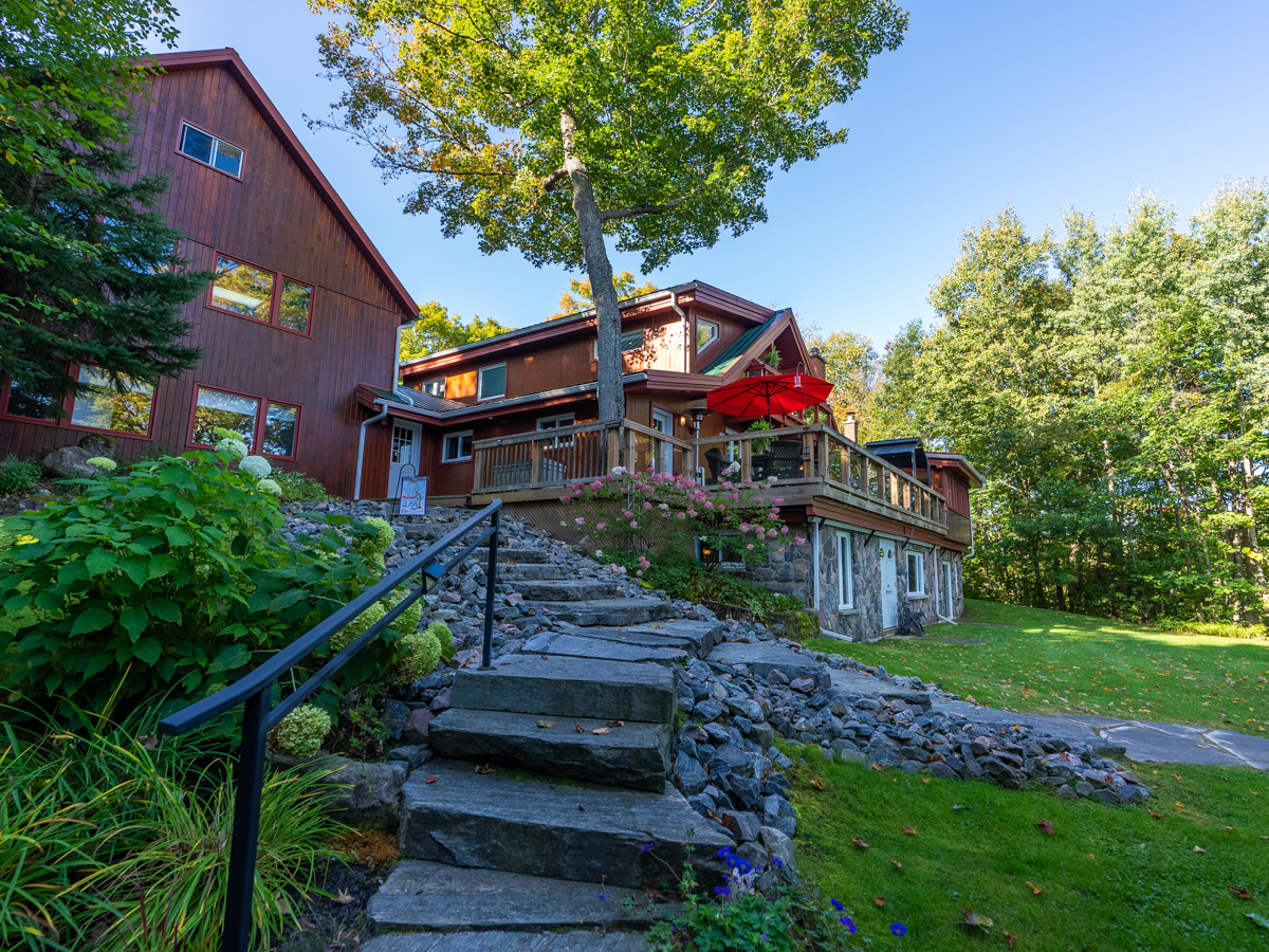 Stone steps lead down from a big cottage toward the lake.