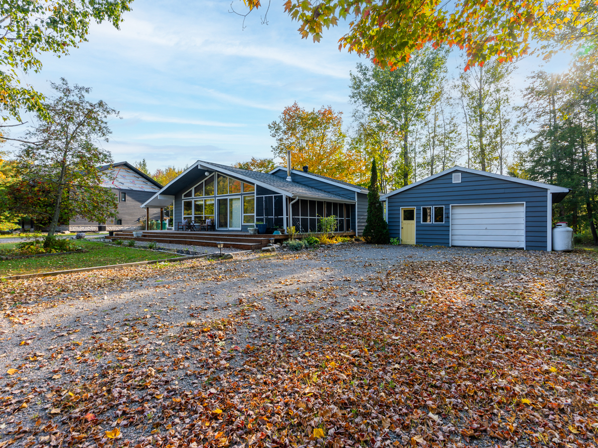 A large driveway leads to a cottage bungalow and a detached garage.